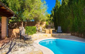 a swimming pool in a yard with two chairs next to it at Sa Plana in Cala Bona