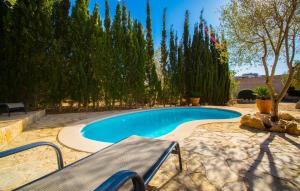 a swimming pool with a bench and trees at Sa Plana in Cala Bona