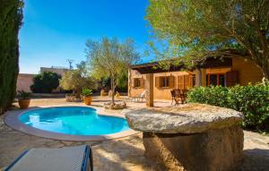 a swimming pool with a stone wall next to a house at Sa Plana in Cala Bona