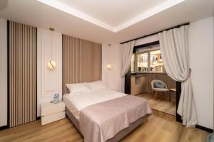 a bedroom with a white bed and a chair at Boutique Centro Hostal in Alicante