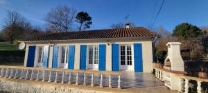 a small blue and white house with a fence at Gîte-La mare aux étoiles in La Douze