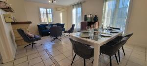 a dining room with a table and chairs and a living room at Gîte-La mare aux étoiles in La Douze