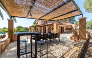 an outdoor patio with a table and chairs under a pergola at Bosco in Sa Coma +44 photos