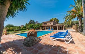 a villa with a swimming pool and a pineapple statue at Bosco in Sa Coma