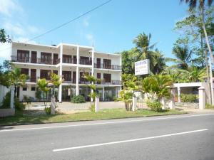 a white building on the side of the road at Hotel Ocean View Cottage in Hikkaduwa