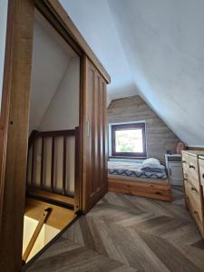 a attic bedroom with a bed and a window at JIROTOVY BOUDY II in Telnice