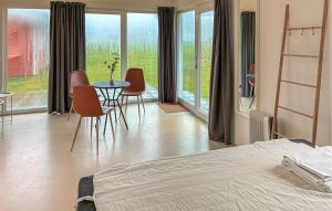 a bedroom with a bed and a table and chairs at Beach Front Home In Samsø With House Sea View in Kolby Kås