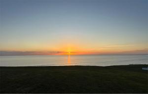 a sunset over the water with the sun setting at Beach Front Home In Samsø With House Sea View in Kolby Kås +6 photos