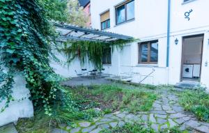 an ivy covered house with a bench in front of it at BEGE APARTMENTS DowntownFlat in Niederdorla