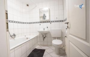 a white bathroom with a toilet and a sink at BEGE APARTMENTS DowntownFlat in Niederdorla +8 photos