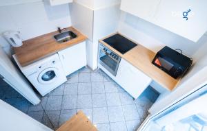 a small kitchen with a sink and a washing machine at BEGE APARTMENTS DowntownFlat in Niederdorla