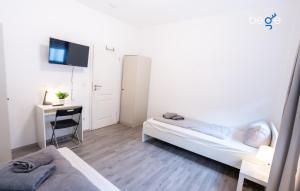a room with two beds and a desk and a tv at BEGE APARTMENTS DowntownFlat in Niederdorla
