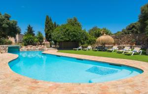 a swimming pool in a yard with chairs at Son Favar in Capdepera