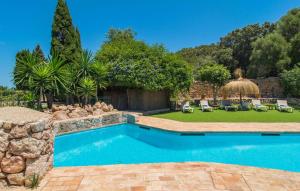 a swimming pool in a yard with chairs and trees at Son Favar in Capdepera