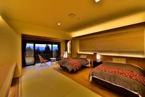 two beds in a bedroom with a balcony at Senjukaku in Yamanouchi +43 photos