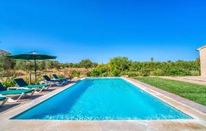 a swimming pool with chairs and an umbrella at S'hortet Gran in Alcudia