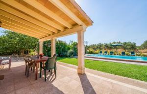 a patio with a wooden pergola and a table and chairs at S'hortet Gran in Alcudia
