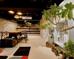 a room with a table and chairs and a tree at Bon Hotel Taipei in Taipei