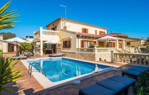 a villa with a swimming pool in front of a house at Manrique in Cala Ratjada