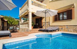 a swimming pool with an umbrella and a house at Manrique in Cala Ratjada +39 photos