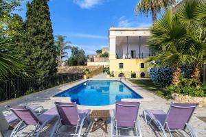 a pool with purple chairs and a house at Catalunya Casas Impressive and Idyllic mansion for up to 40 people! in Banyeres del Penedes