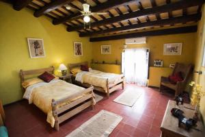a bedroom with two beds in a room with yellow walls at Catalunya Casas Impressive and Idyllic mansion for up to 40 people! in Banyeres del Penedes +55 photos