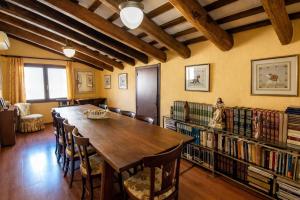 a room with a long table and a library with books at Catalunya Casas Impressive and Idyllic mansion for up to 40 people! in Banyeres del Penedes