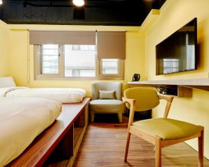 台北的住宿－台北旅坊，客房设有两张床、椅子和书桌。