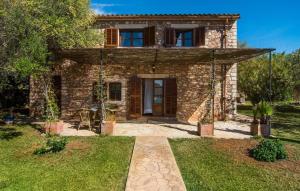 a stone house with a front door and a yard at Mirabo Ramonet in Felanitx