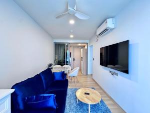 a living room with a blue couch and a table at Skypark New Building 4th floor Mountain View in Laguna Phuket