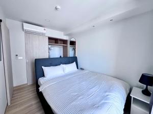 a bedroom with a bed with a blue headboard at Skypark New Building 4th floor Mountain View in Laguna Phuket