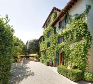 a building covered in ivy next to a street at Villa Le Barone in Panzano