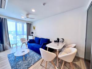 a living room with a blue couch and a table at Skypark New Building 4th floor Mountain View in Laguna Phuket