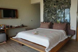 a bedroom with a large white bed in a room at The Puncak Lombok in Senggigi +37 photos