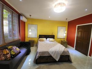a bedroom with a bed and a couch at Hilltop Villa Chez Coco in Rodney Bay Village