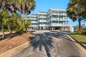 a large building with palm trees in front of it at Baywatch C10 in Pensacola Beach