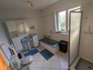 a bathroom with a tub and a toilet and a sink at LOGEMENT 110m2 CHEZ TITI in Ittenheim