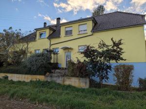 a yellow house with a black roof at LOGEMENT 110m2 CHEZ TITI in Ittenheim