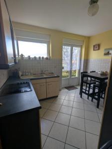 a kitchen with a sink and a table in it at LOGEMENT 110m2 CHEZ TITI in Ittenheim