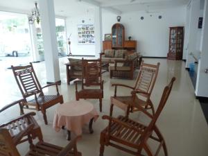 a room filled with wooden chairs and a table at Hotel Ocean View Cottage in Hikkaduwa