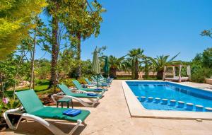 a row of chaise lounge chairs next to a swimming pool at Pambola in Caʼs Concos