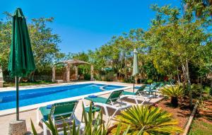 a swimming pool with lawn chairs and umbrellas at Pambola in Caʼs Concos