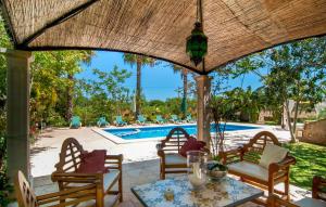 a patio with chairs and a table and a pool at Pambola in Caʼs Concos