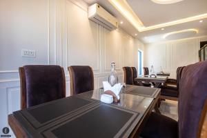 a conference room with a table and chairs and a bottle of wine at Hotel Classy Castle in Kolur