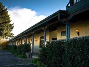 a side view of a building with bushes and trees at Sonoma Creek Inn in Sonoma