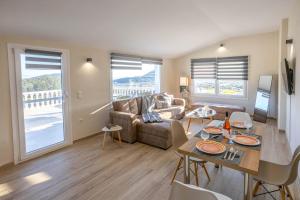 un soggiorno con un divano e un tavolo di Olive Waves apartments a Néa Péramos
