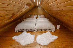 a bedroom with two beds in a wooden attic at The Forest Nest in Dealu Armanului