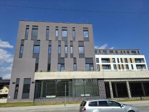 a building with a car parked in front of it at Top Apartmán v Central Point Humenné M in Humenné