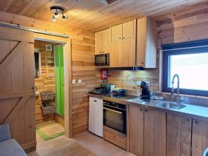 a kitchen with wooden cabinets and a sink in a cabin at La Bucolique de Tahier in Ohey +21 photos