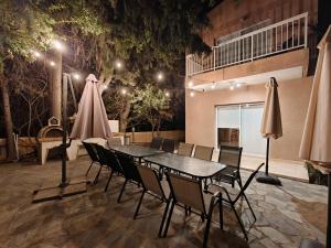 a patio with a table and chairs and umbrellas at Villa Green Sea in Paphos
